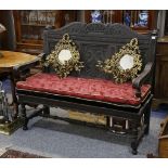 A pair of Victorian ebonised hall benches, with carved decoration and squab cushions, in antique