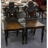A pair of Victorian oak hall chairs.