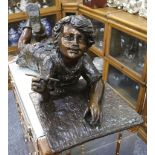 A large bronze of a boy writing on the floor, 106cm wide.