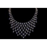 A yellow metal and sapphire lattice pendant bib necklace, set numerous oval cut sapphires in open