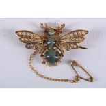 An unusual yellow metal, chrysoberyl, seed pearl, and ruby set brooch in the form of a bee, having