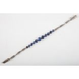 A silver and sapphire bracelet, set eleven oval cut graduated blue sapphires of approx. 4 carats