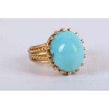 A yellow metal and turquoise ring, having rope twist mount and claw-set cabouchon turquoise,