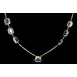 An  18 carat yellow gold, aquamarine, and sapphire necklace, suspended 19 cushion cut openwork set
