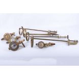Four heavy brass spirit dispensers with clamps and optics by Gaskell & Chambers Ltd.