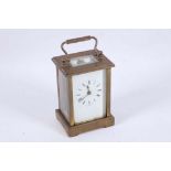 A 20th Century English brass carriage clock with wing handle, white enamelled dial with Roman