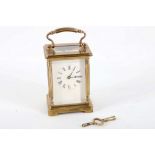 An Edwardian 5 glass brass carriage clock, white enamelled clock face with black Roman numerals in
