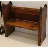A Victorian church pew, having oak ends carved with nuts and leaves, with pine back and seat,