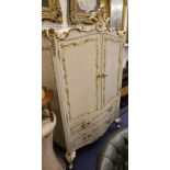 A decorative cream painted rococo style gilt decorated wardrobe of small size, 102cm wide.