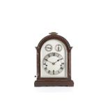 AN EDWARDIAN MAHOGANY QUARTER CHIMING MUSICAL MANTEL CLOCK the break-arch case surmounted by a brass