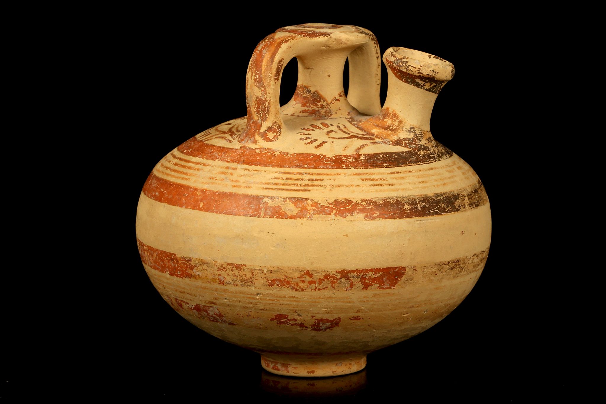 A MYCENAEAN STIRRUP JAR Circa 1400-1300 B.C. Of globular form, with central spout and strap handles,