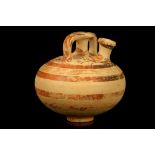 A MYCENAEAN STIRRUP JAR Circa 1400-1300 B.C. Of globular form, with central spout and strap handles,