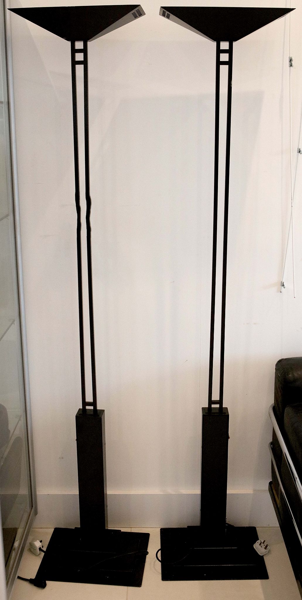 A pair of black finished floor standing uplighters, in the manner of Mackintosh.