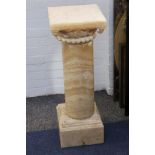 An alabaster jardiniere stand with square base and carved capital.