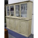 A cream painted four door dresser in two sections.