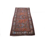 A collection of four small rugs, including an Afghan Ghanzni a Persian Sirjan, a mat and a bag face.