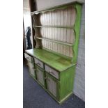 A kitchen dresser in green & cream painted pine, having 2 shallow shelves over drawers and