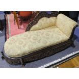 A colonial carved and pierced chaise lounge with upholstered seat.