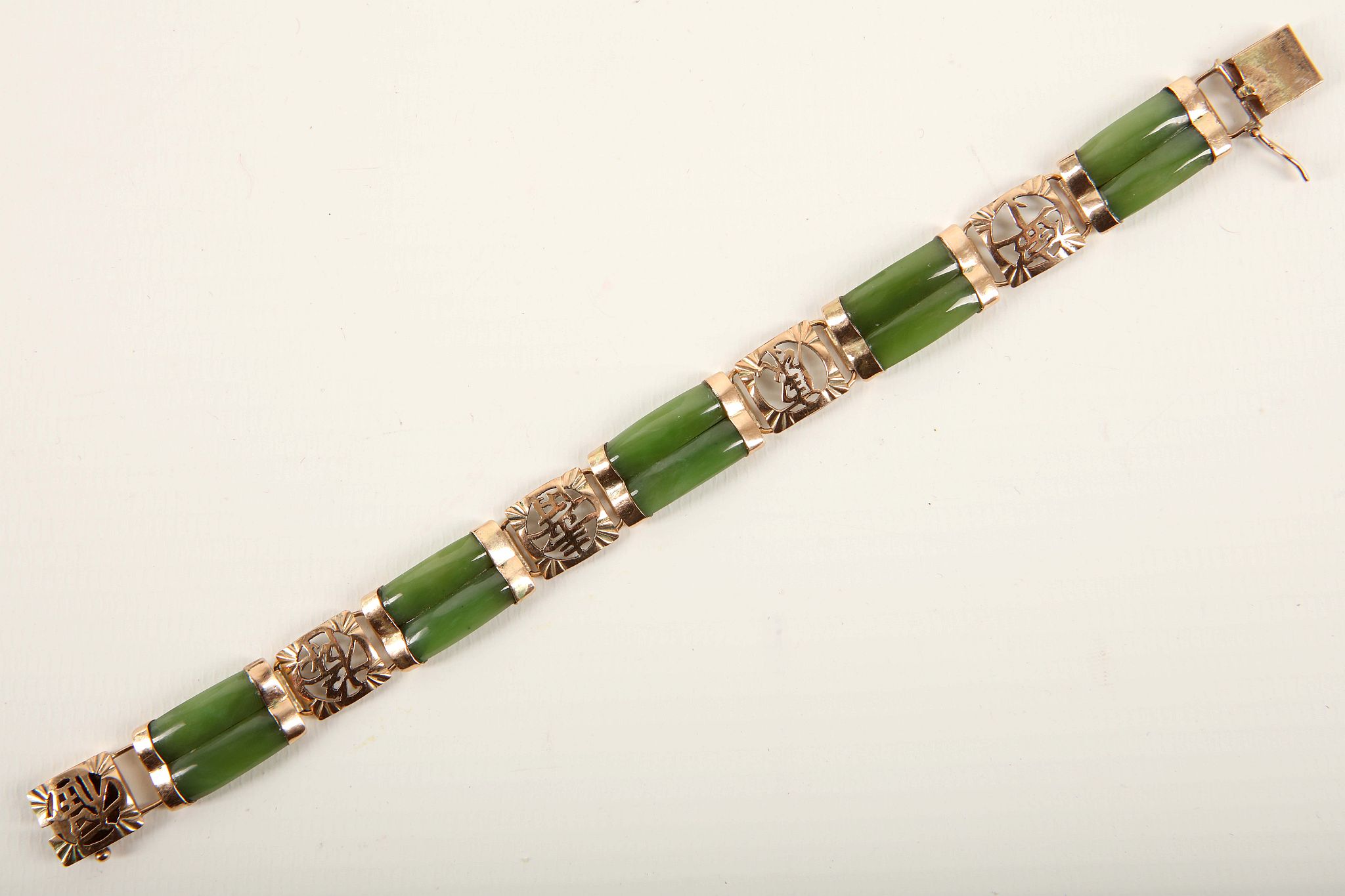 A vintage Chinese jade and gold bracelet c.1950, the curved two two nephrite bars with yellow gold