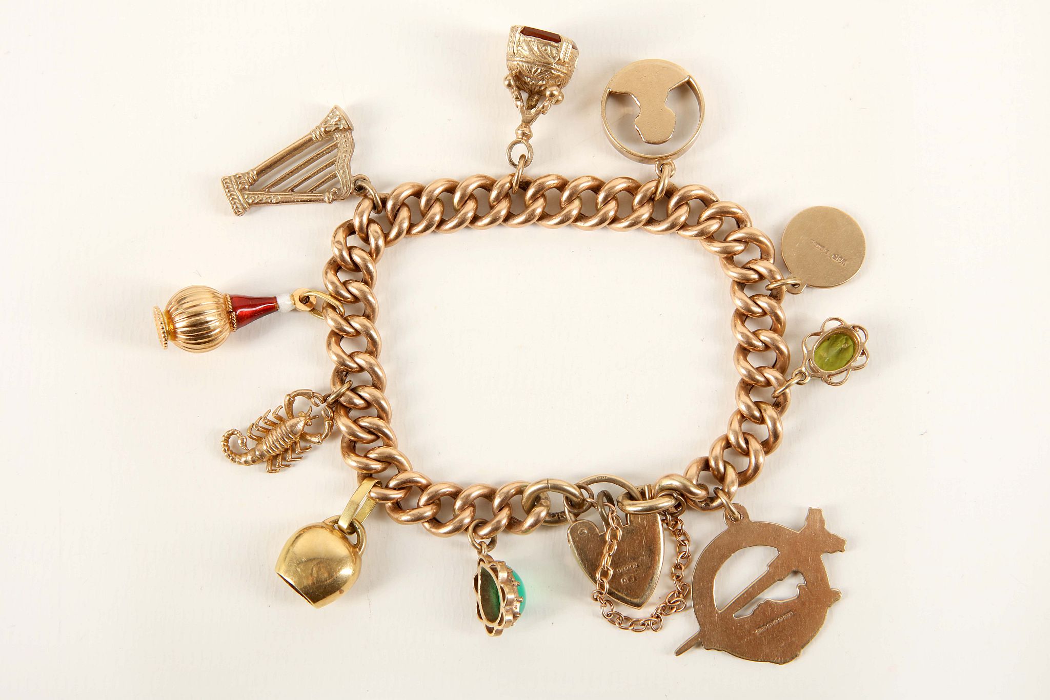 A vintage 9ct yellow gold charm bracelet, the hollow curb link bracelet with heart shaped clasp, ten - Image 2 of 2