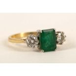 An 18ct gold, emerald and diamond three stone ring, the emerald cut main stone flanked by