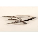 A 1970's platinum and diamond brooch, with three arrowhead interlocking design, the smallest set