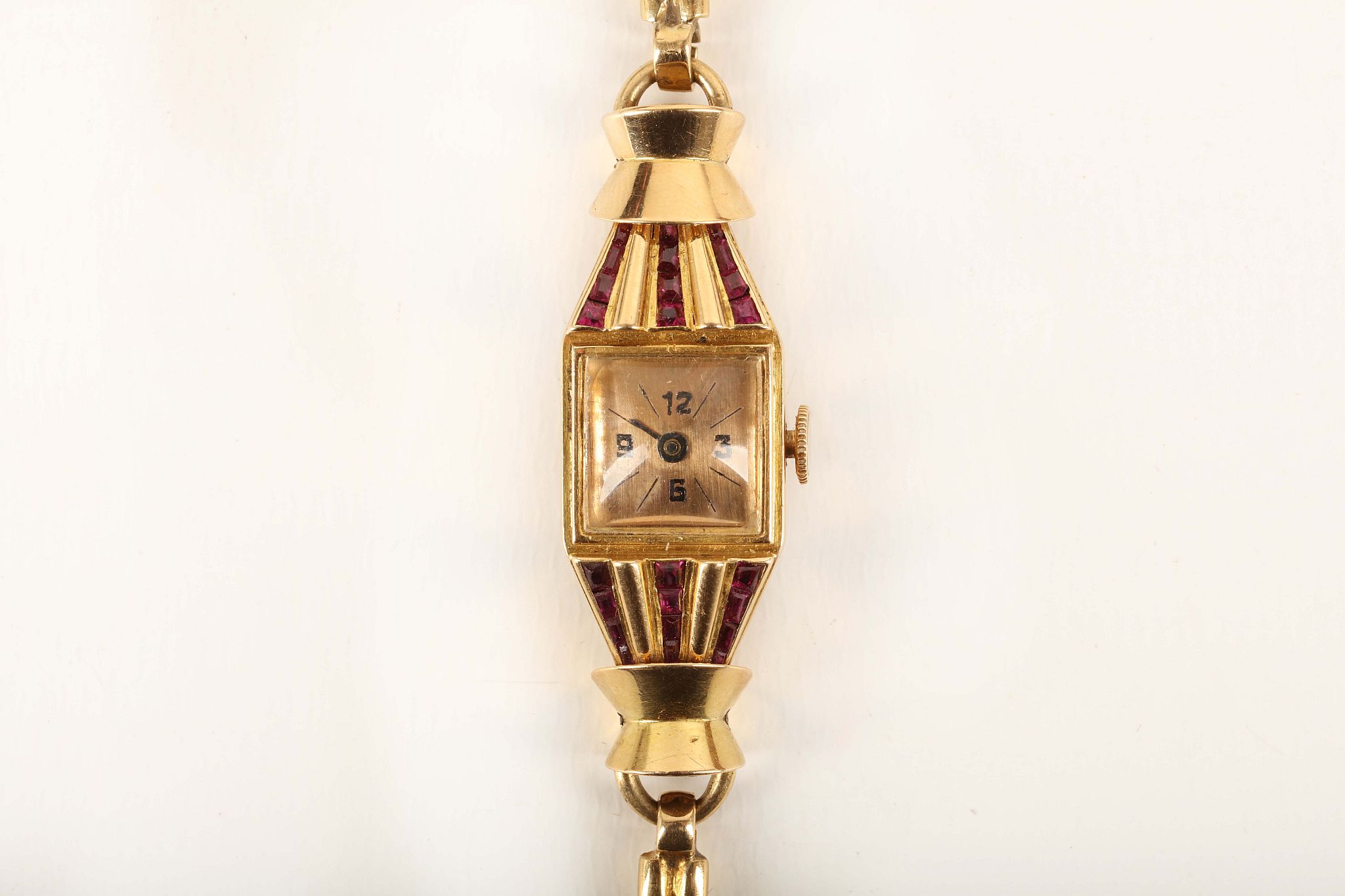 A ladies c.1940's French 18ct gold cocktail watch, the case set with rubies and having articulated