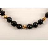 A black onyx and yellow gold bead necklace, comprising sixty onyx beads with nineteen spiral