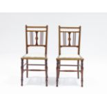 A pair of Edwardian inlaid mahogany chairs with upholstered seats, on turned front legs with