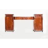 A Regency mahogany pedestal sideboard, the bowfront top fitted two drawers, on panelled cupboards