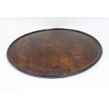 A circular mahogany tray with dished top,