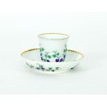 A 19th Century Meissen beaker and saucer, each moulded with fruiting vines, the saucer painted