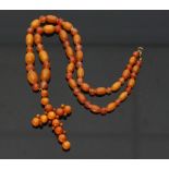 An amber cross, the circular beads of butterscotch colour, 6.