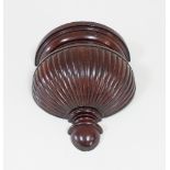 A carved walnut half-round wall bracket,