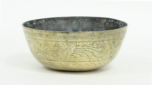 A Chinese circular brass bowl engraved a band of stylised designs within a Greek key border,