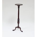 A mahogany torchere with reeded baluster column, on tripod support,