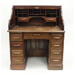 An Edwardian mahogany estate desk by Simpole's Office Furniture, Manchester with tambour fall and