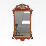 A Chippendale period upright wall mirror, having shaped ear pieces and a carved bird surmount,