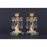 A pair of 19th Century ormolu candlesticks, each raised on dolphin supports and with drop lustres,