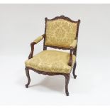 A carved walnut armchair of 18th Century design with upholstered seat,