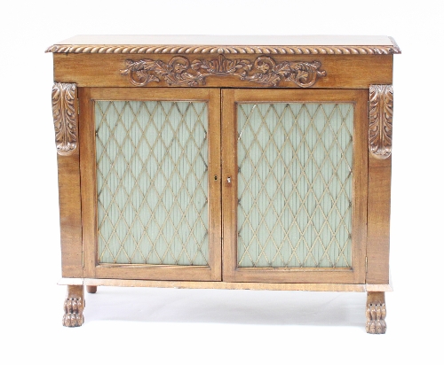 A Regency mahogany cabinet enclosed by a pair of doors with brass grilles,