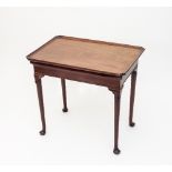 A George II mahogany silver table, the dished rectangular top with indented corners, fitted a side