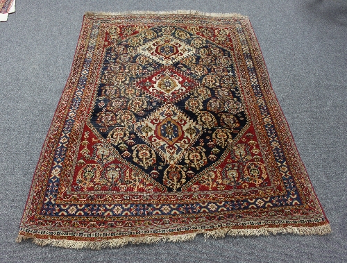 A Hamadan rug with three pole medallions to the central blue ground geometric field within a