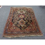 A Hamadan rug with three pole medallions to the central blue ground geometric field within a