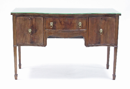 A mahogany sideboard of Sheraton design, fitted a drawer and two cupboards to the serpentine front,