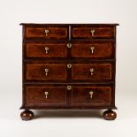 A William and Mary burr yew and walnut chest of two short and three long graduated drawers on bun