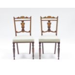 A pair of Edwardian mahogany single chairs, the backs inlaid with satinwood urns and ivory