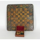 A 19th Century penwork chess board decorated with various symbols in the squares within a flower
