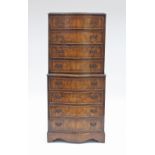 A figured walnut serpentine front tallboy chest of eight long drawers, on bracket feet, 62.25cm wide