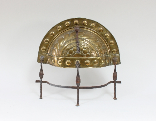 A brass and steel curfew guard, gadrooned brass on an iron stand,